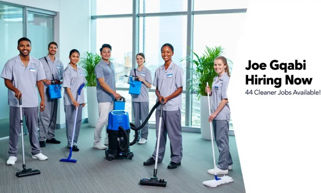 A group of happy, diverse people in uniforms cleaning a bright office environment, smiling and holding cleaning tools like mops, vacuum cleaners, and sprays. Office plants, sparkling windows, and a well-lit, modern interior in the background. with text overlay: “Joe Gqabi Hiring Now – 44 Cleaner Jobs Available!”